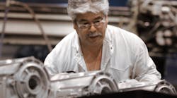 A General Motors worker operating a high-pressure aluminum diecasting machine producing transmission parts at Bedford, IN.