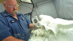 A Ford Motor technician works with a 3Dprinted prototype for an engine design A Ford Motor technician works with a 3Dprinted prototype for an engine design