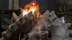 A worker at ESCO&rsquo;s Main Plant in Portland uses an angle grinder to finish a cutting head for a dredging machine head.