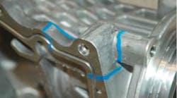 Blue paint outlines the areas of material and/or structural vulnerability in an aluminum casting.