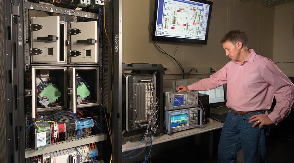 NIST engineer Rick Candell works with a testbed to evaluate how different plant layouts will affect wireless radio frequencies, and thereby influence the performance of a Smart factory.