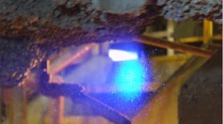 An inoculant illuminated by the line laser during mold filling.