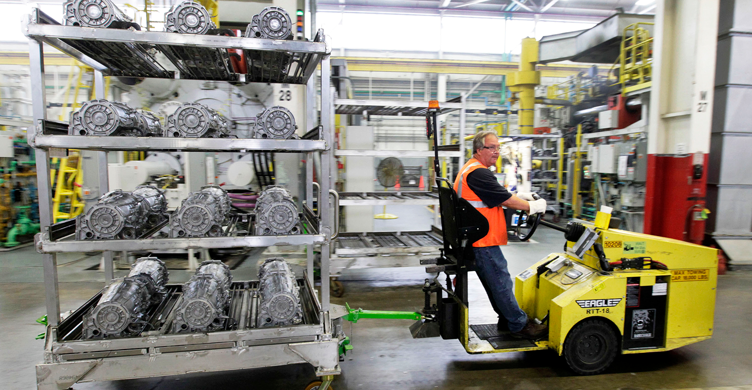 A GM worker hauls aluminum castings.at the Bedford, IN, casting plant.