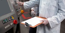 Two factory engineers operating a machine, with a clipboard. Two factory engineers operating a machine, with a clipboard.