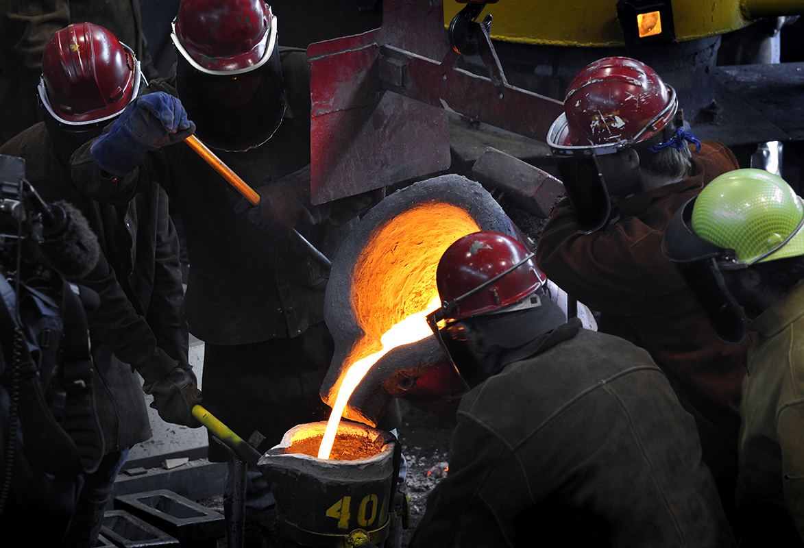 Metalcasters at work together at ladle pouring.