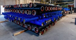 Cast iron pipe products on pallets in a warehouse. Cast iron pipe products on pallets in a warehouse.