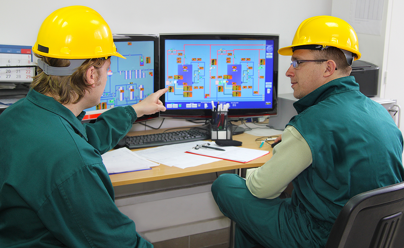 Industrial workers in control room.