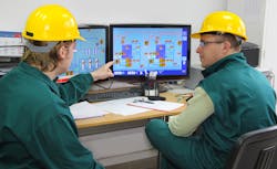 Industrial workers in control room. Industrial workers in control room.
