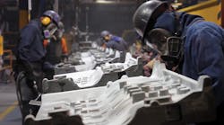 Workers grind engine castings at Teksid Hierro, a gray and ductile iron foundry. Workers grind engine castings at Teksid Hierro, a gray and ductile iron foundry.