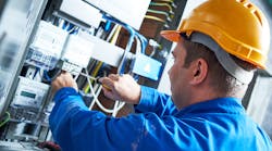 Electrician installing energy saving meter into switch box panel. Electrician installing energy saving meter into switch box panel.