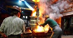 Workers in a foundry casting a metal workpiece - safety at work and teamwork. Workers in a foundry casting a metal workpiece - safety at work and teamwork.
