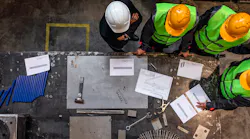 Factory workers review plans together.