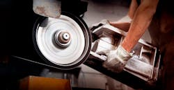 Hand-grinding a green sand casting at Wisconsin Aluminum Foundry. Hand-grinding a green sand casting at Wisconsin Aluminum Foundry.