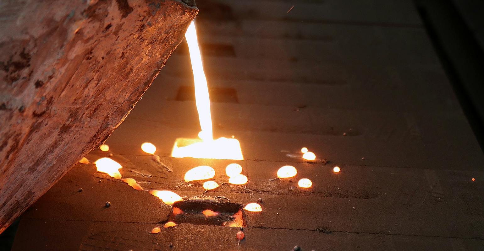 Molten metal poured into green sand molds.