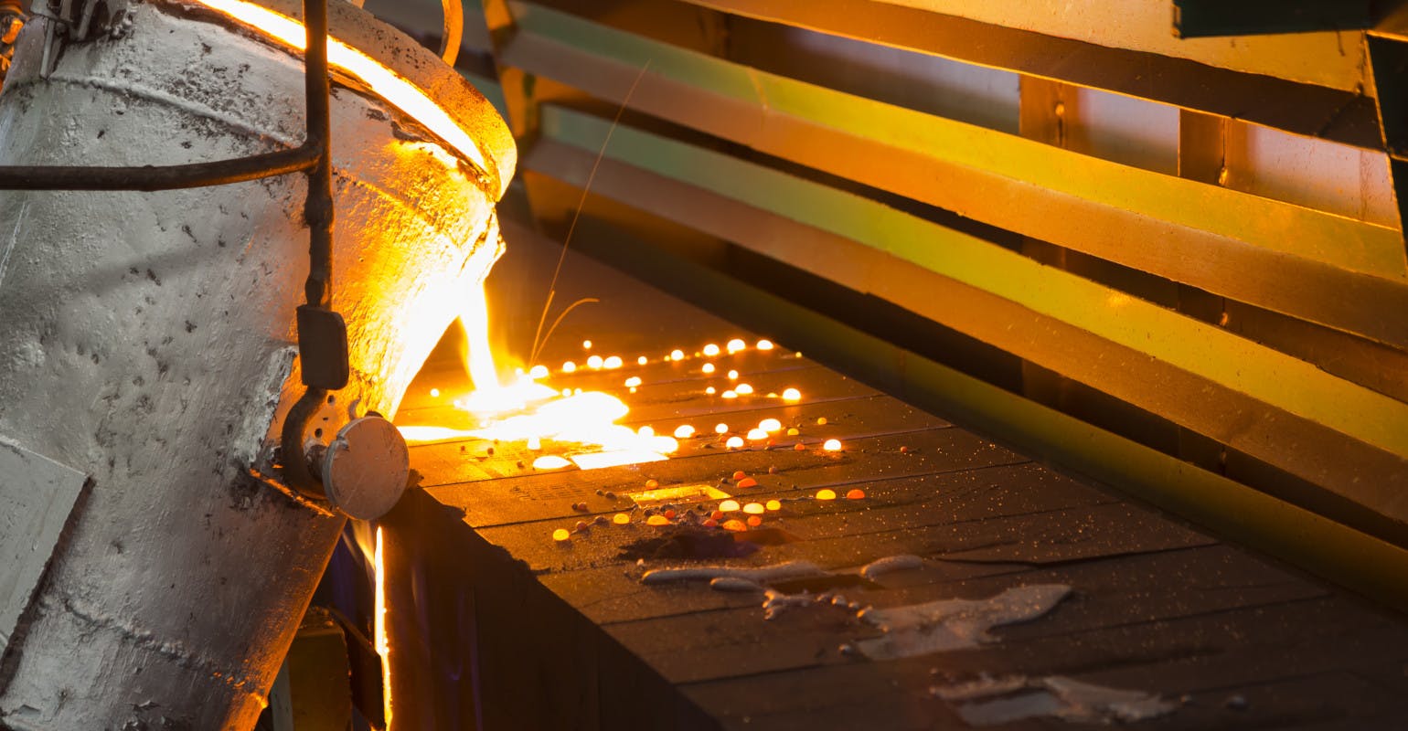 Pouring molten iron into green sand molds.