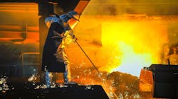 Worker on steel melt deck with sampling equipment. Worker on steel melt deck with sampling equipment.