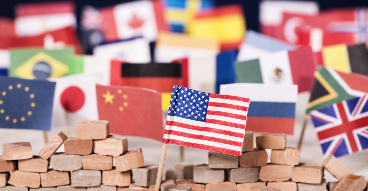 American flag in front of a wall and flags of other countries