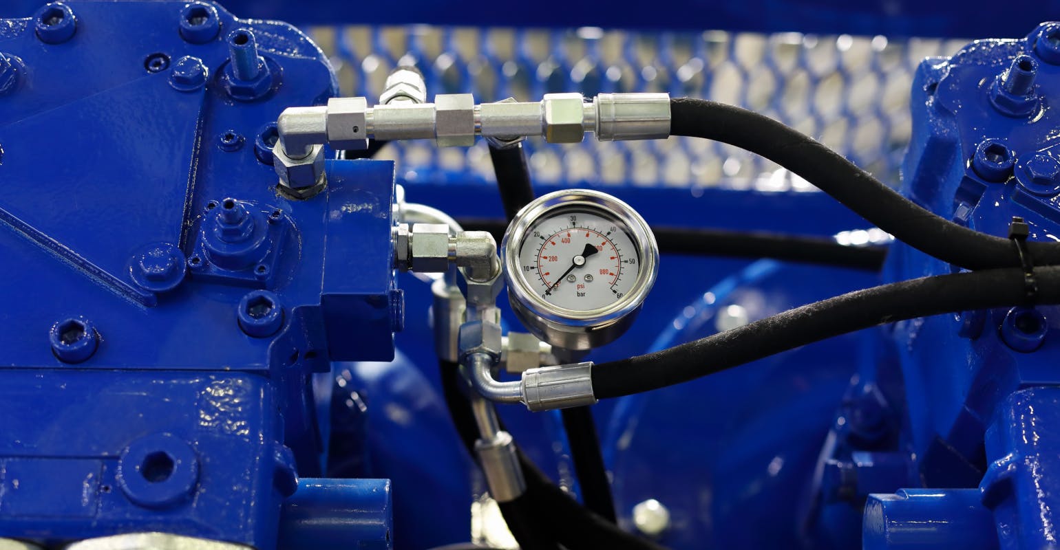 Closeup view of air compressor with pressure gauge.