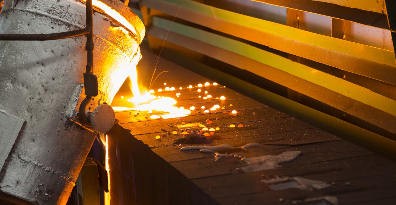 Pouring molten iron into green sand molds