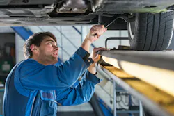 Mechanic checks auto suspension.