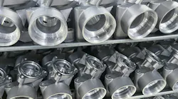 Machined, diecast automotive aluminum parts on a rack.