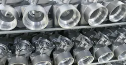 Machined, diecast automotive aluminum parts on a rack.